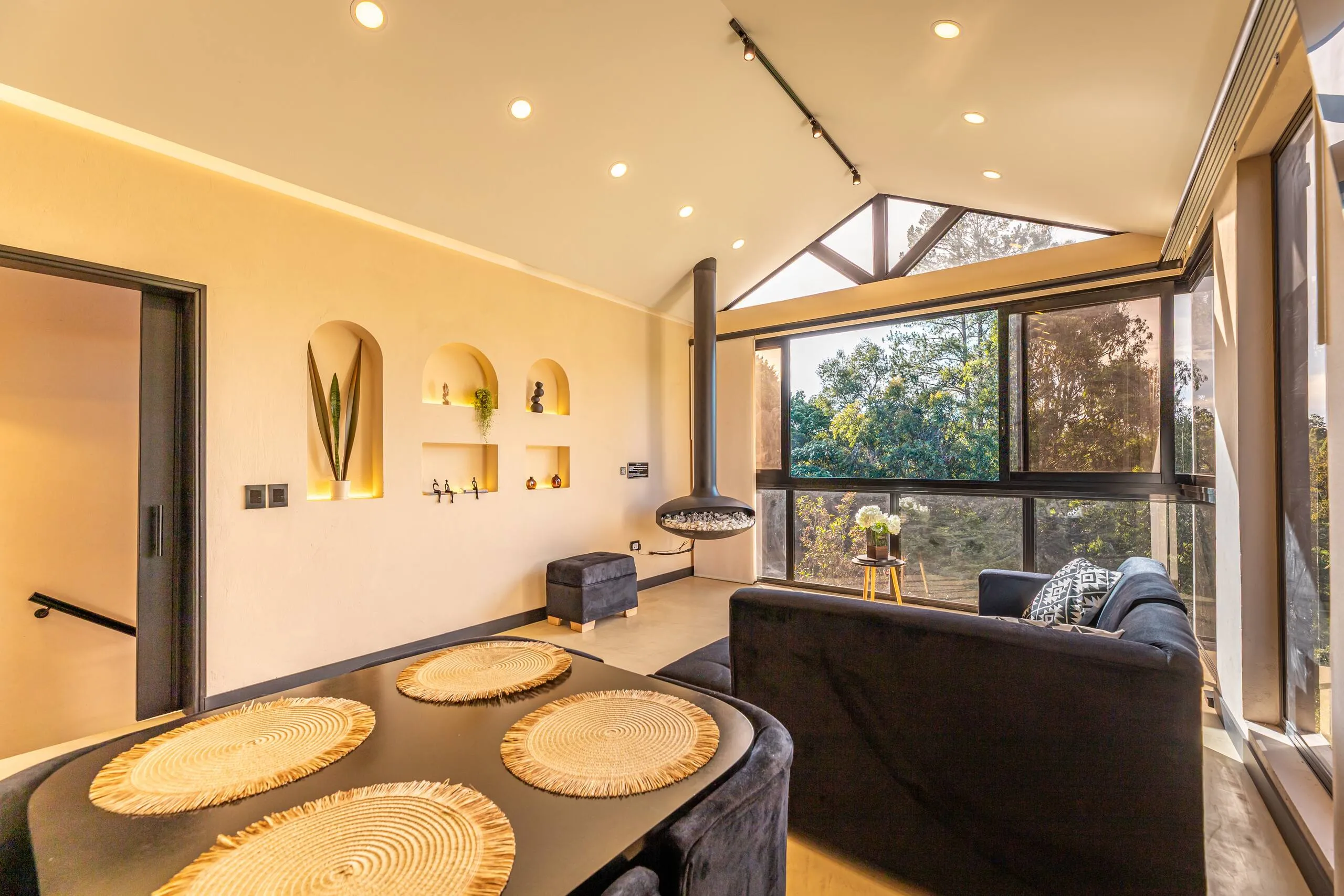 The great room, vaulted ceiling, dining table and glass held open to the forest