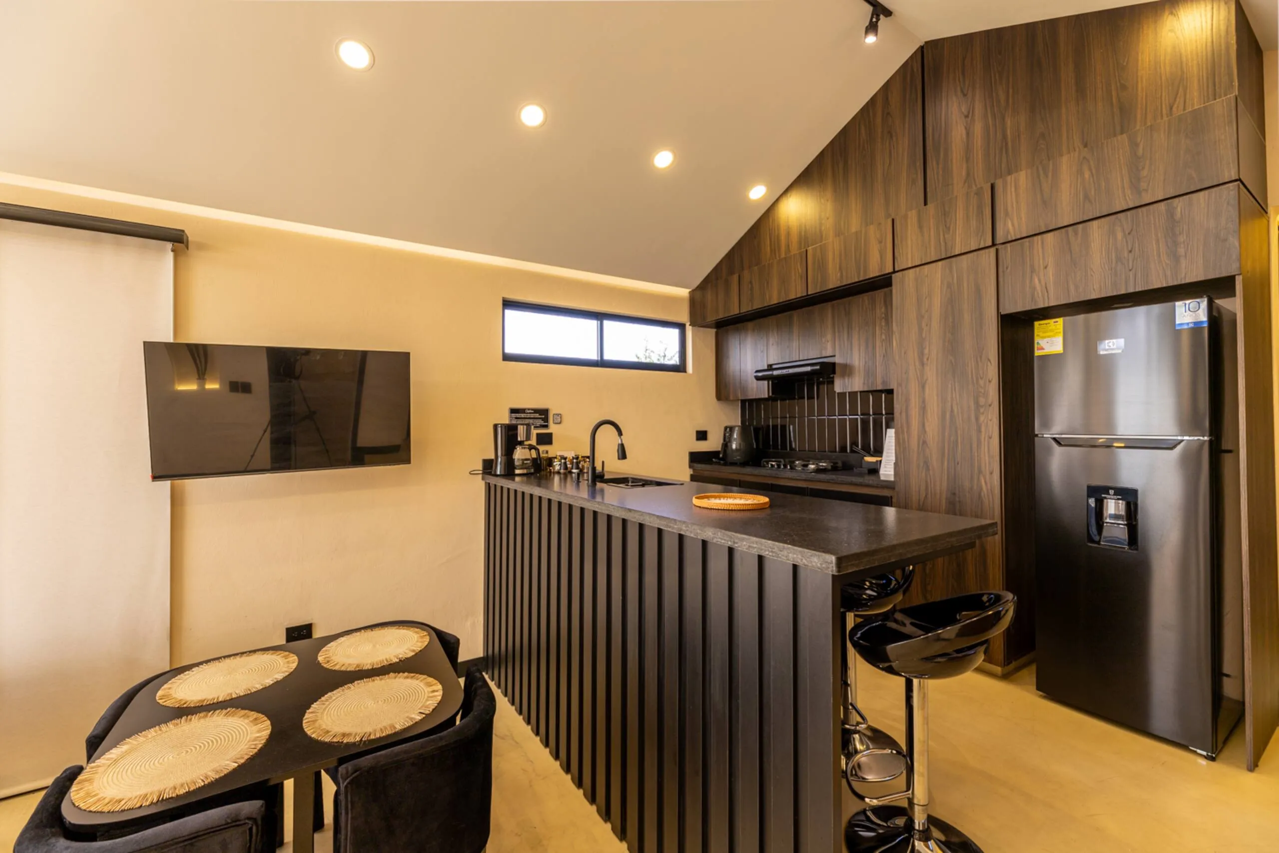 The gourmet kitchen, dark stone counter, timber cabinetry and bar seating