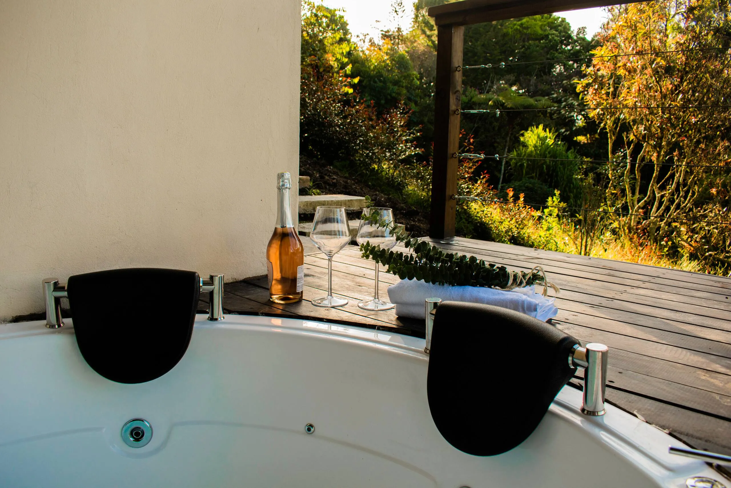 The jacuzzi beside a window, looking out over the treetops