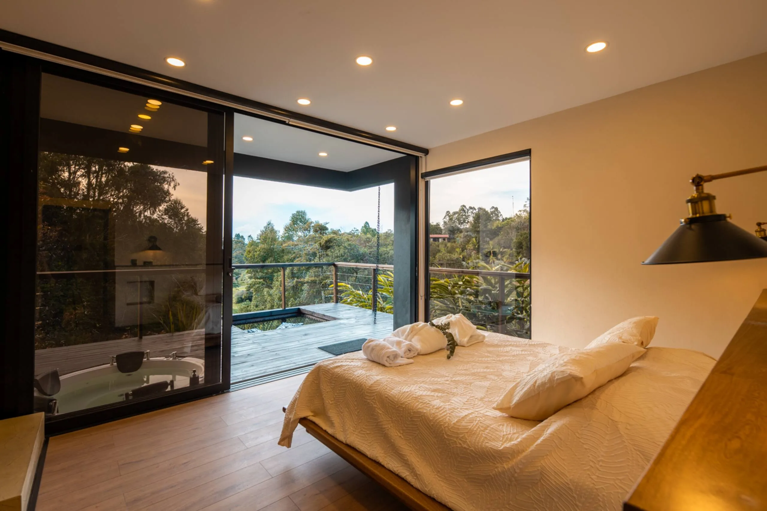 A bedroom with a corner window framing the hills